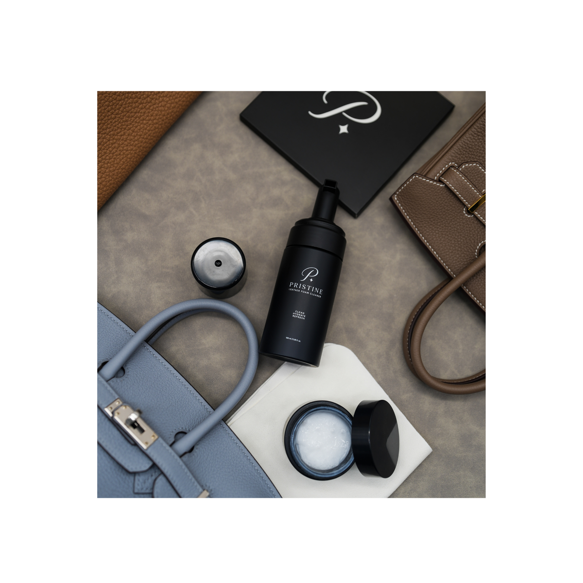 Overhead view of PRISTINE Foam Cleaner, open lotion jar and white cloth surrounded by leather handbags.